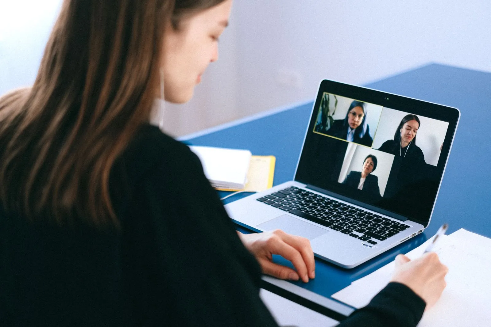 Mulher em uma videochamada de trabalho pelo notebook, em casa
